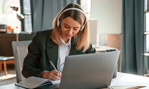 Kobieta siedząca przy laptopie na kursie zajęć językowych online.